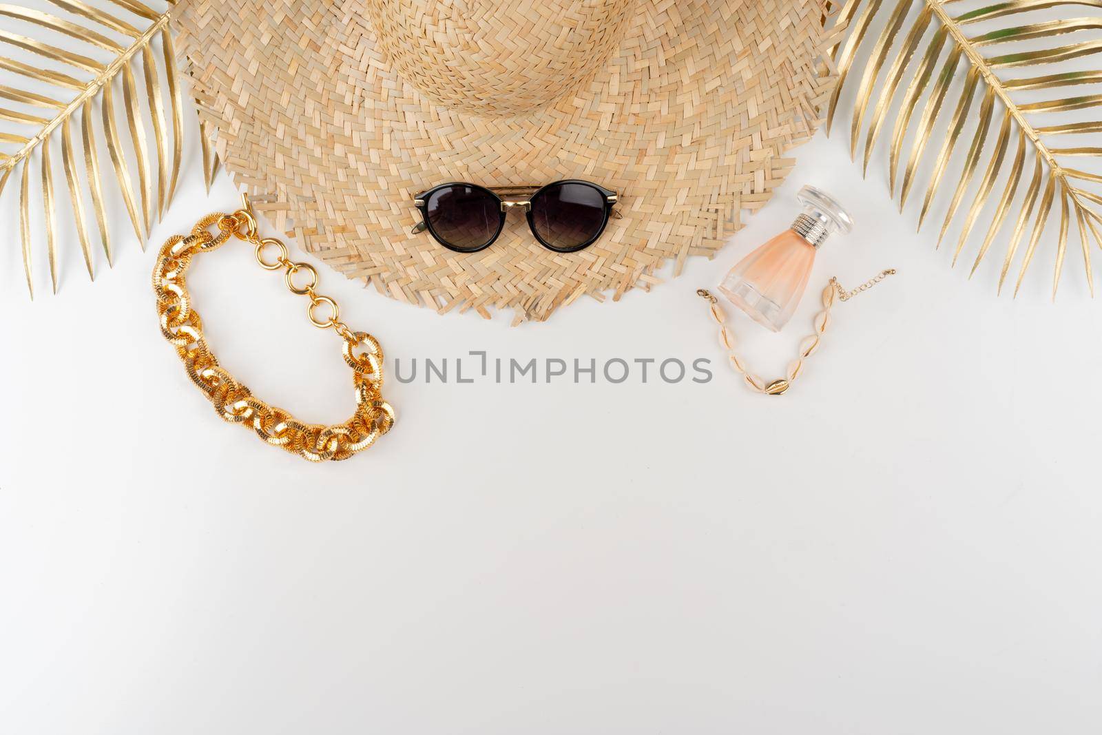 Straw hat and sunglasses top view on white background. Close up.