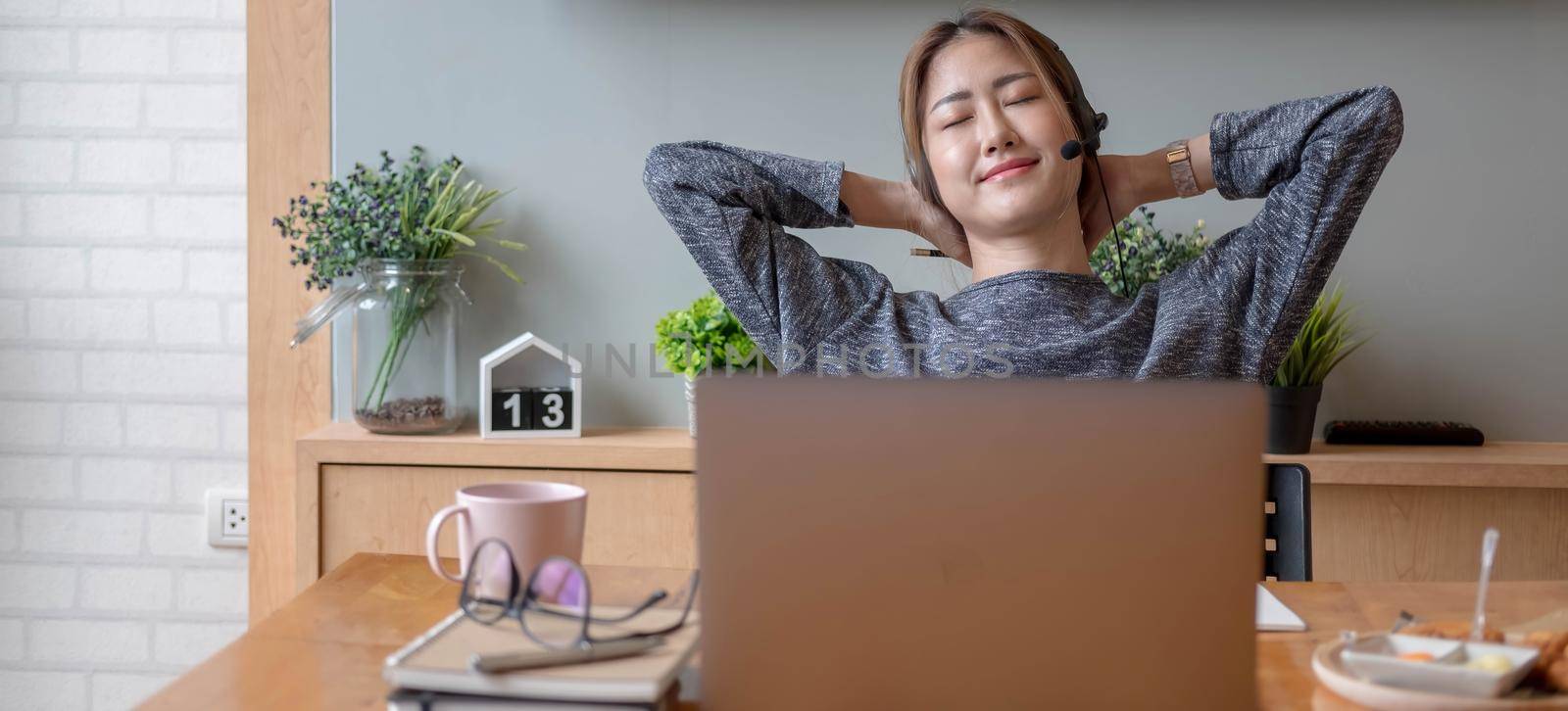 Cropped shot smiling asian woman freelancer wearing headset, communicating with client via video computer call. Millennial pleasant professional female tutor giving online language class.