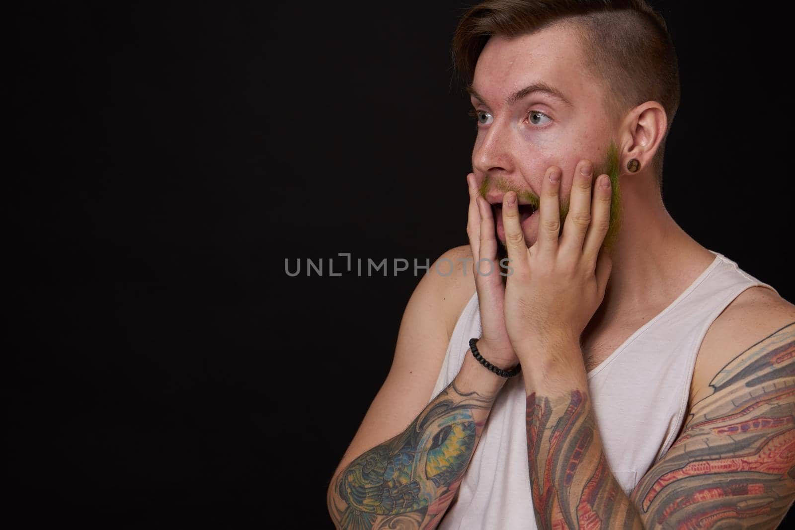 stylish bearded man in a white t-shirt with tattoos on his arms fashion. High quality photo