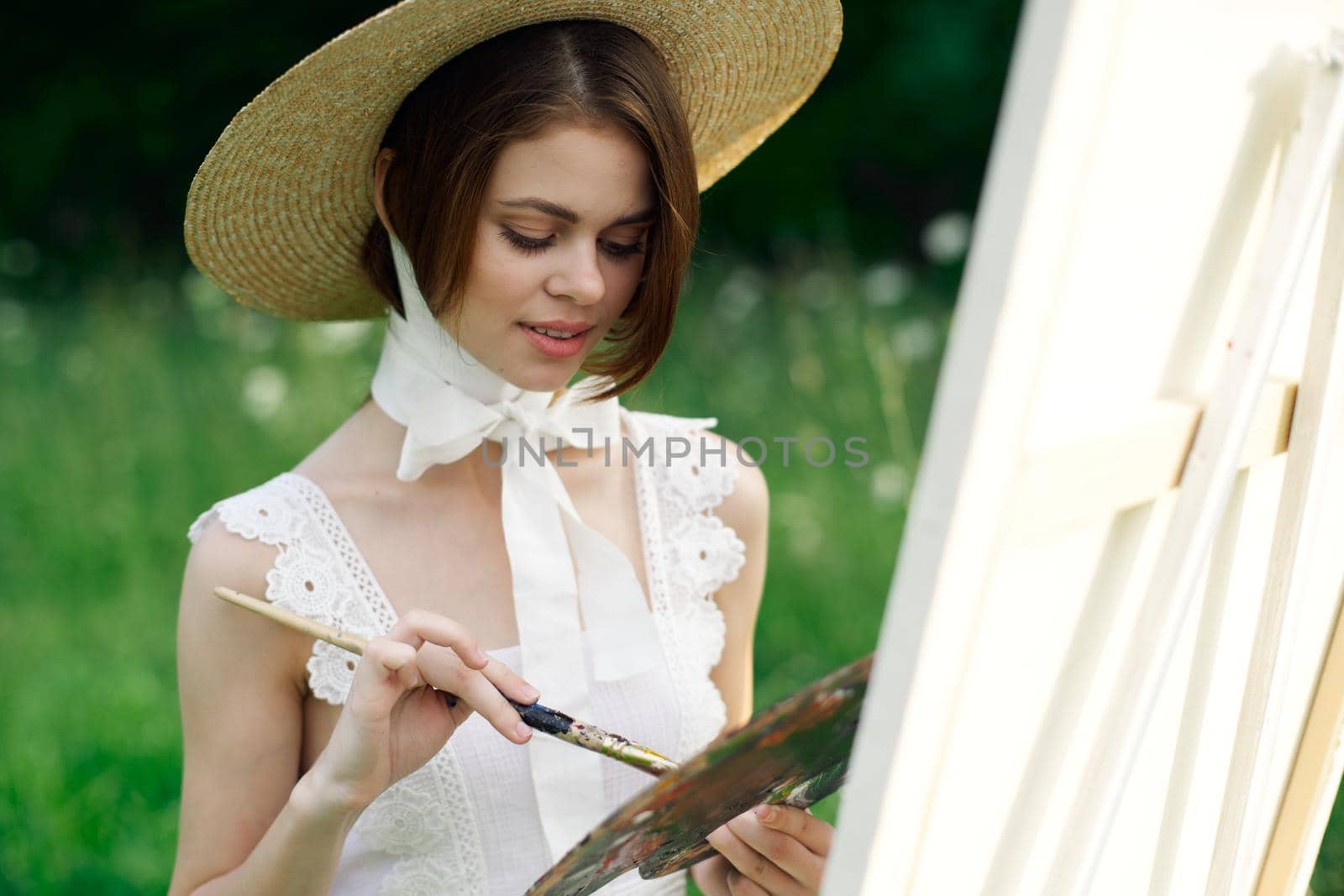 woman artist view with paint palette draws a picture in nature by Vichizh