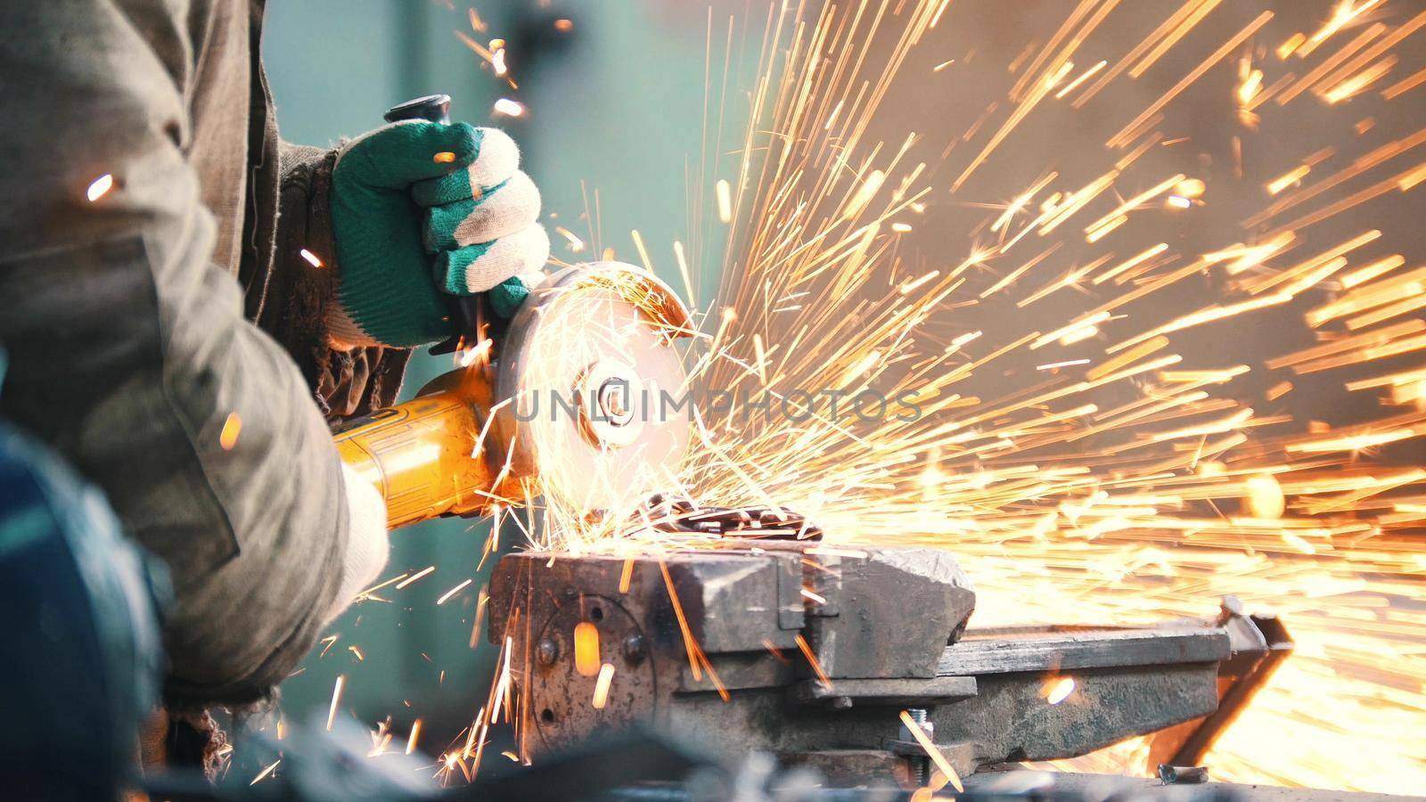 Industrial. Construction site. The man worker grinding. Fire sparkles. Mid shot