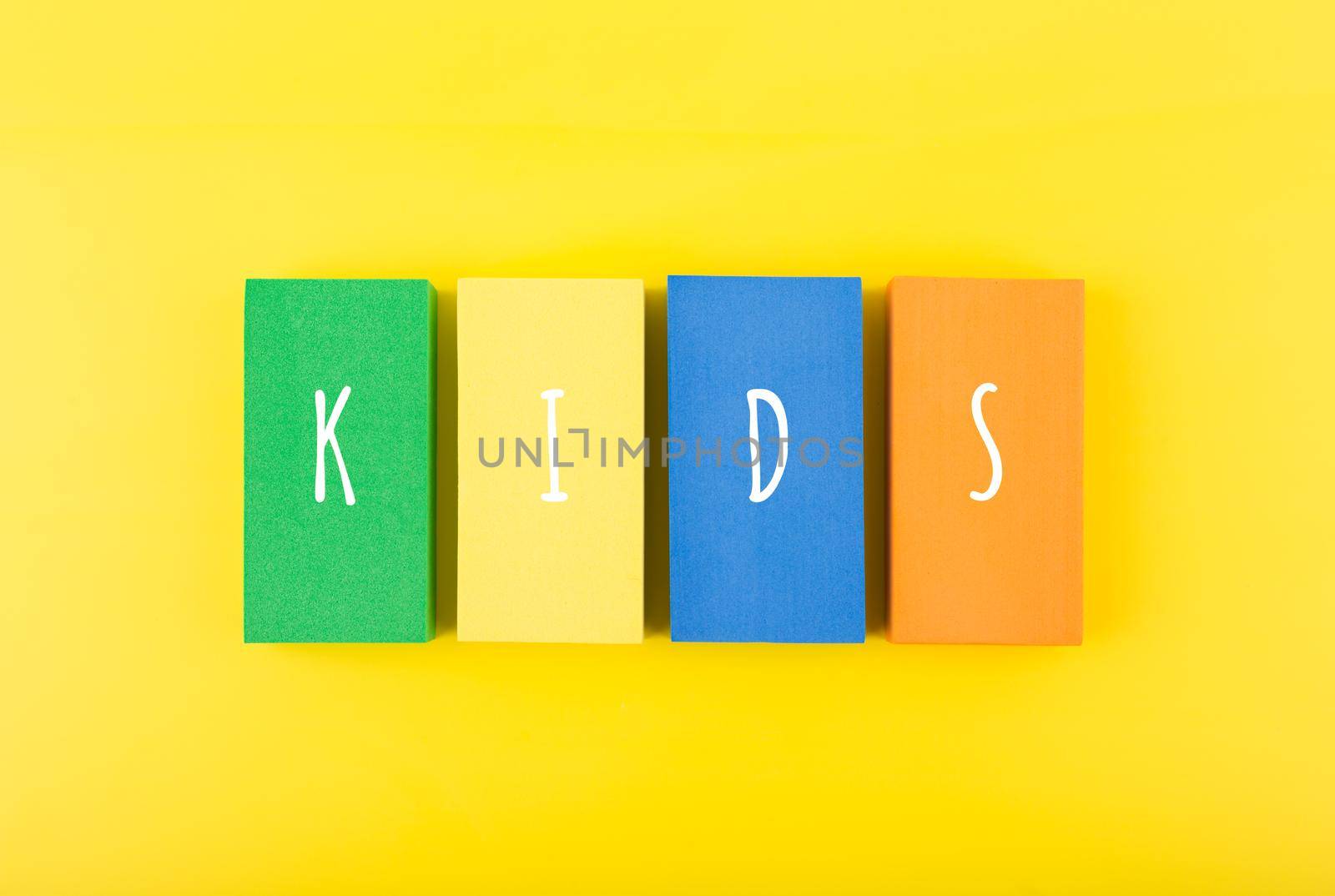 Word kids on colorful rectangles against bright yellow background. Concept of pre school, kindergarten, child care center
