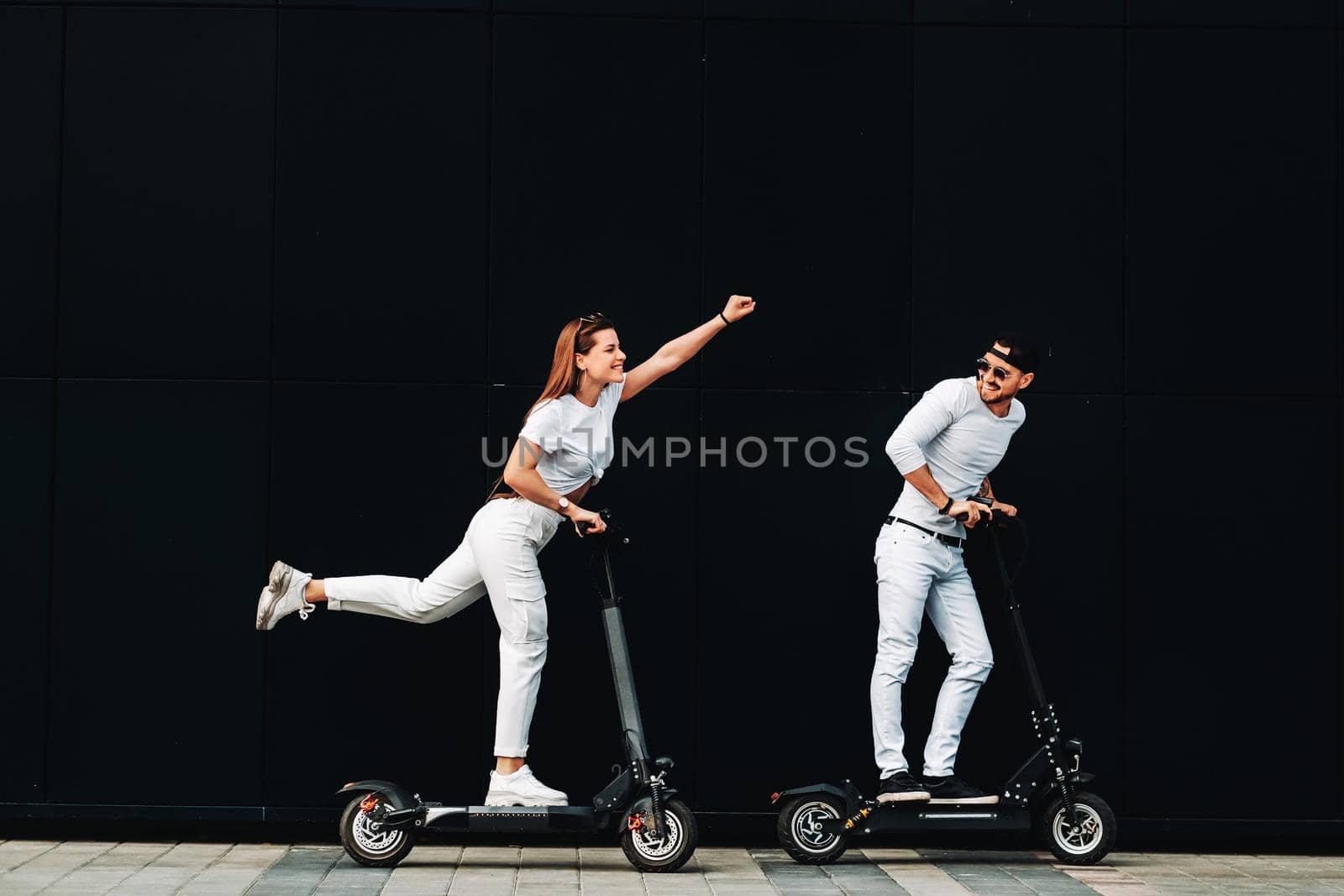 A girl and a guy are walking on electric scooters around the city, by Lobachad
