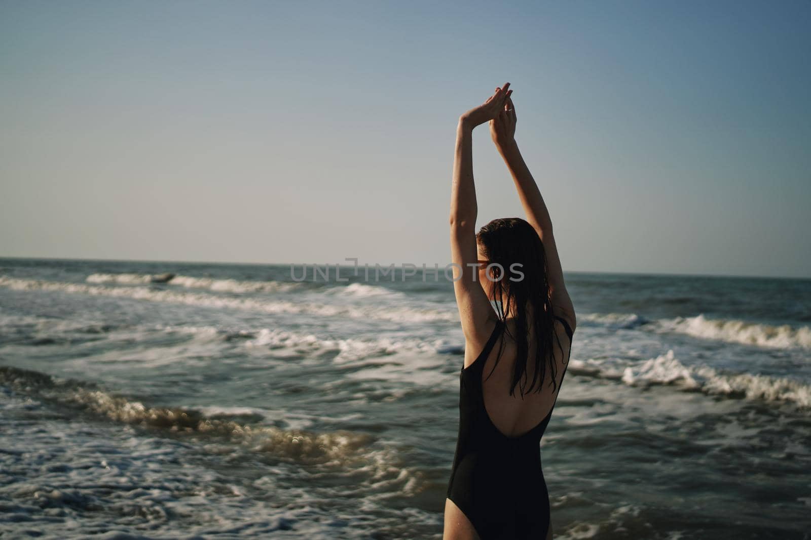 woman in black swimsuit walking on the beach ocean summer. High quality photo
