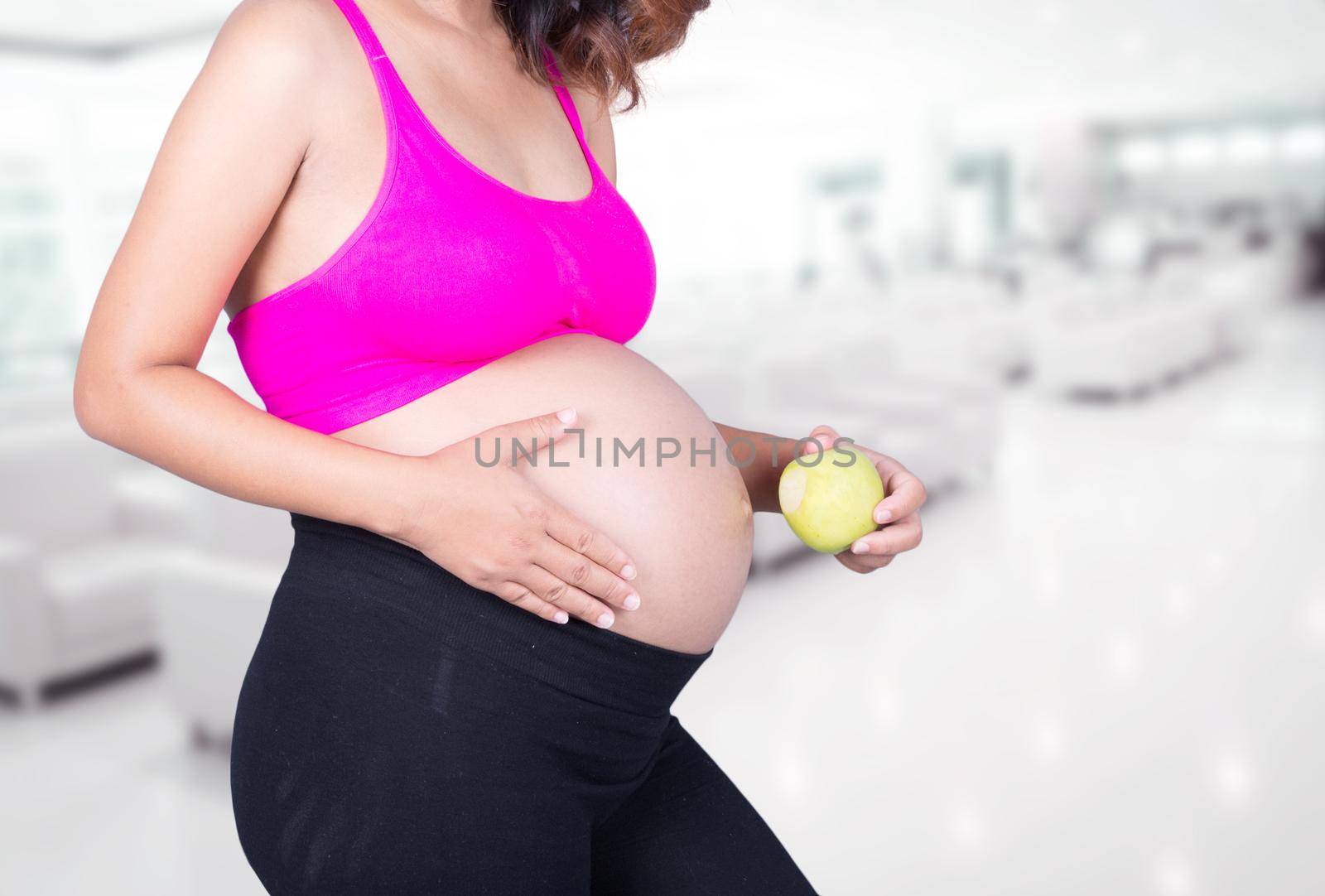 pregnant woman with green apple in hospital background