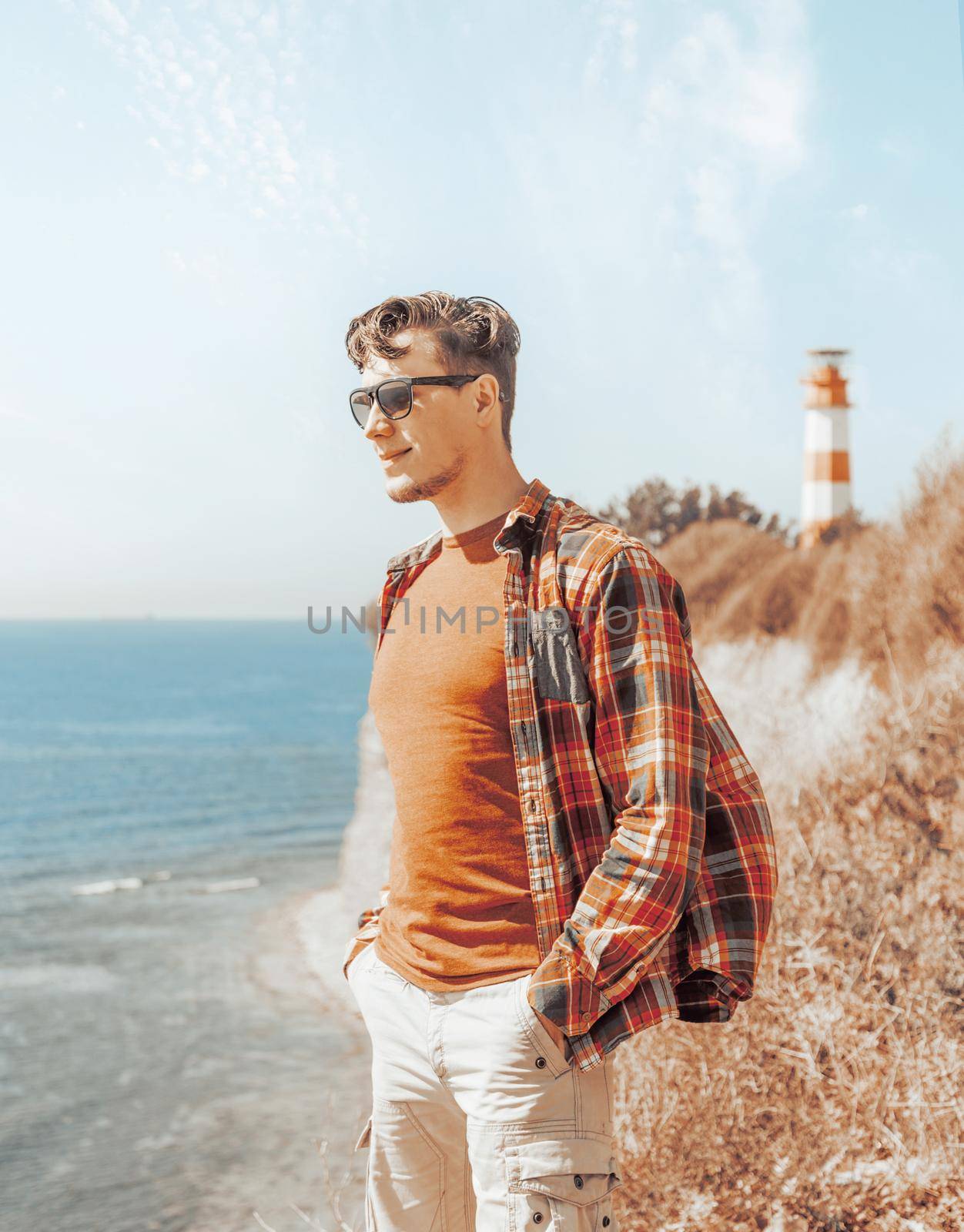 Stylish young man standing on coast. by alexAleksei