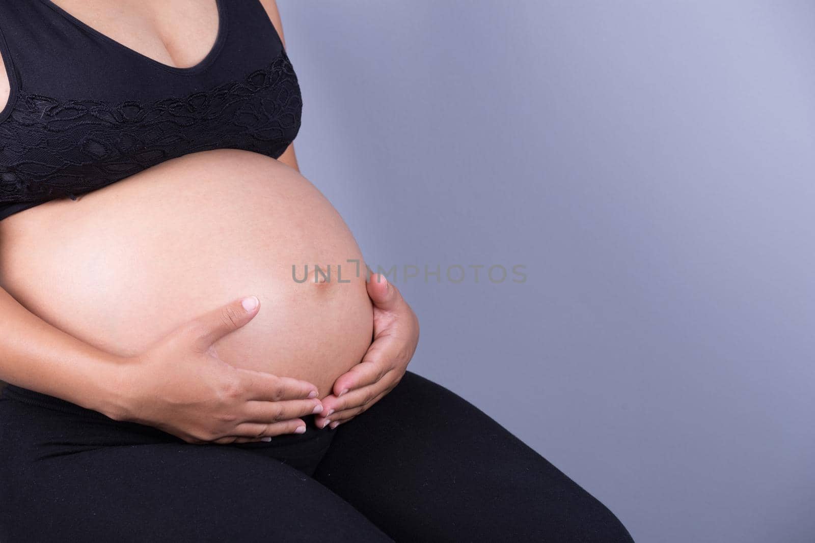 Close-up of pregnant woman belly with her hand on it