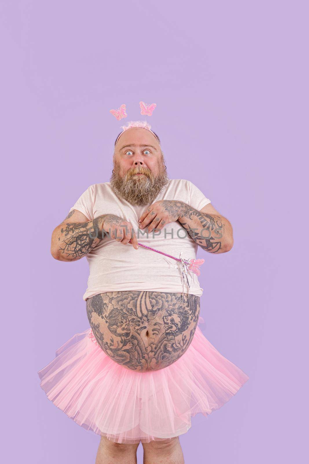 Shocked bearded man with overweight in fairy costume on purple background by Yaroslav_astakhov