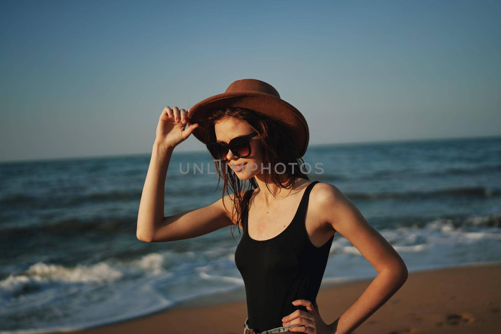 pretty woman in hat walking on the beach ocean travel. High quality photo