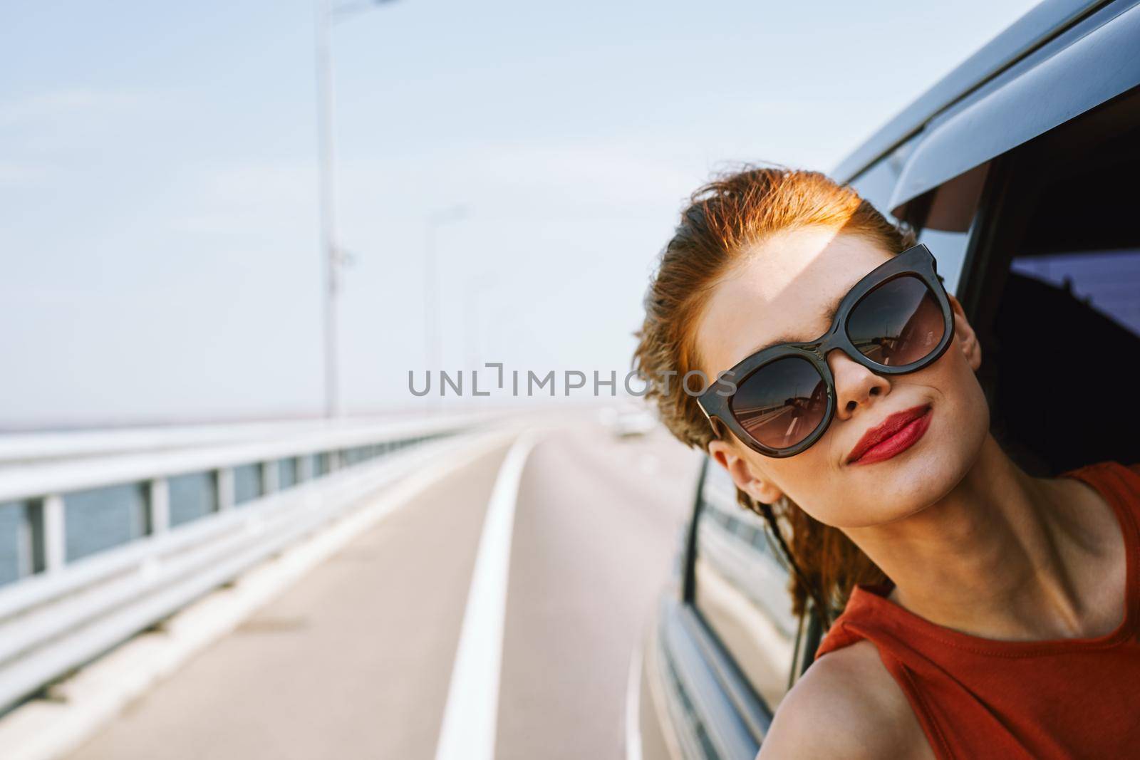 woman looking out of car window wearing sunglasses travel lifestyle. High quality photo