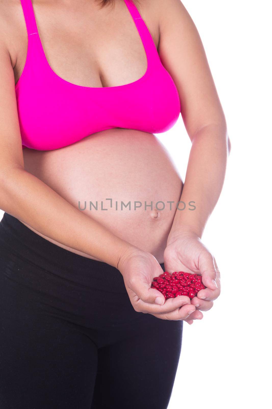 pregnant woman with red pills in her hands on white background by geargodz