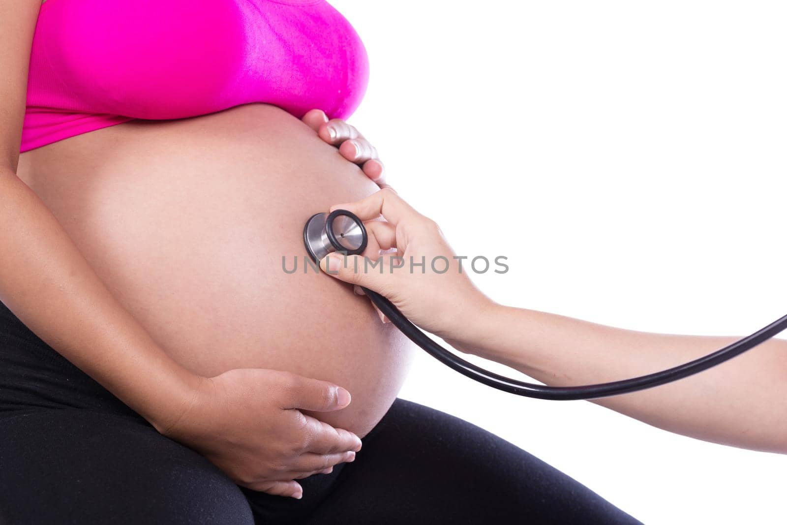 Belly of a pregnant woman examined with a stethoscope by geargodz
