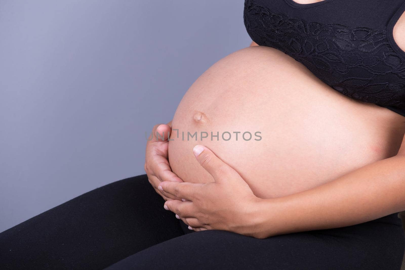 Close-up of pregnant woman belly with her hand on it