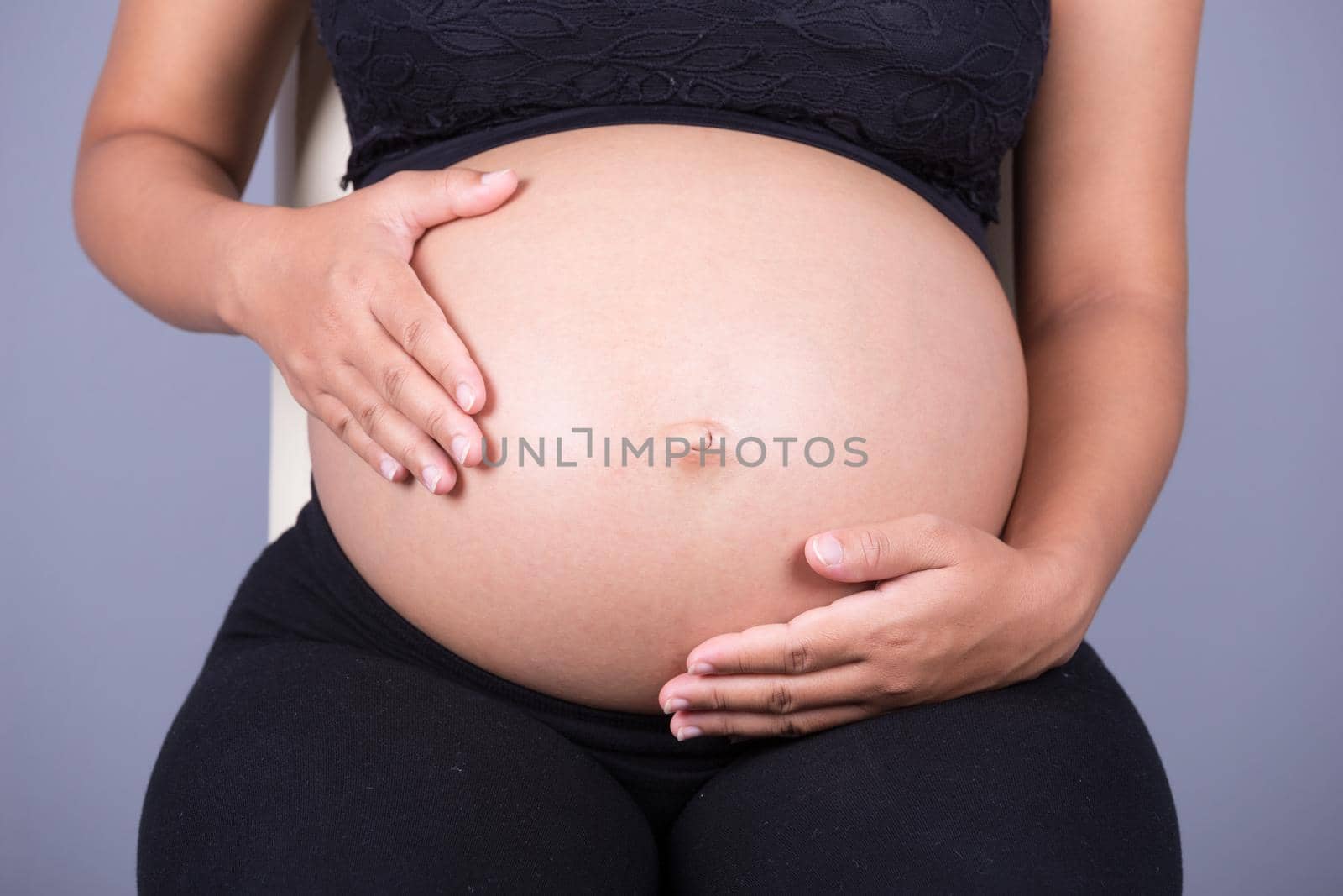 Close-up of pregnant woman belly with her hand by geargodz