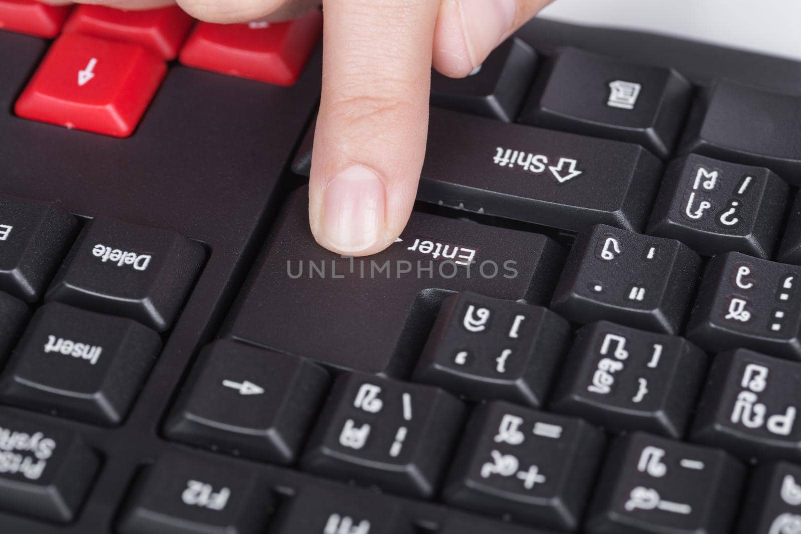 finger pushing enter button on keyboard of computer by geargodz