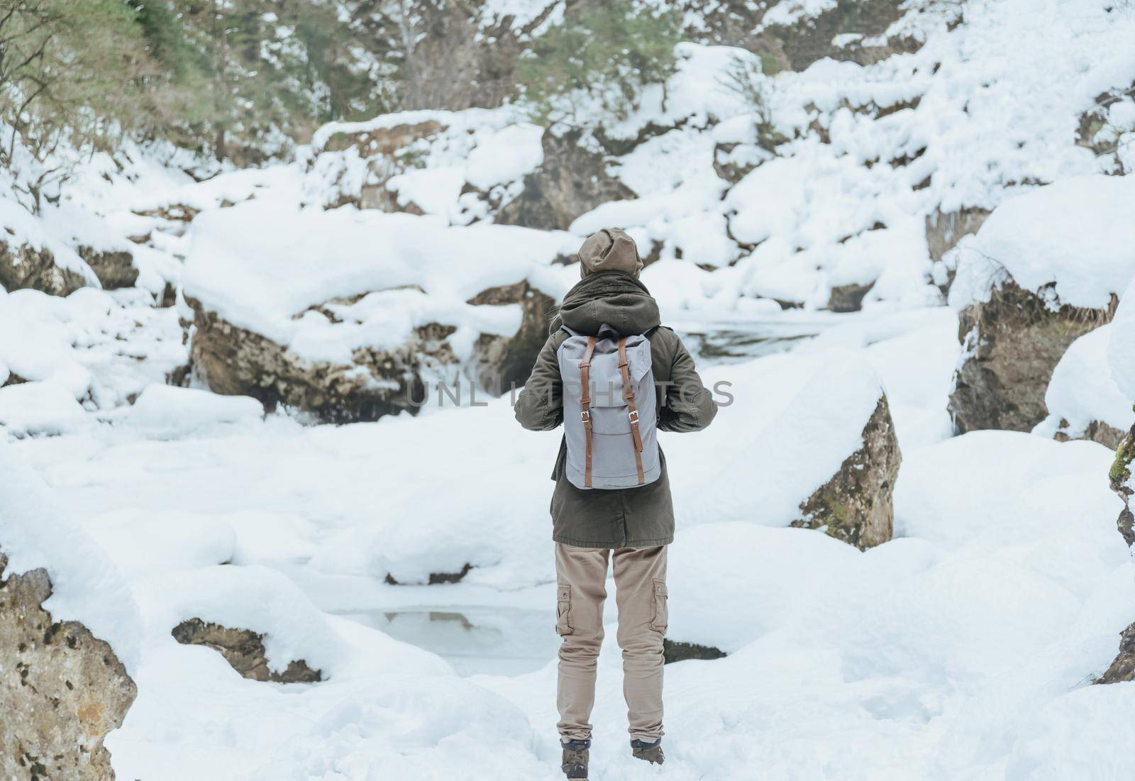 Unrecognizable hiker young woman with backpack walking in winter outdoor