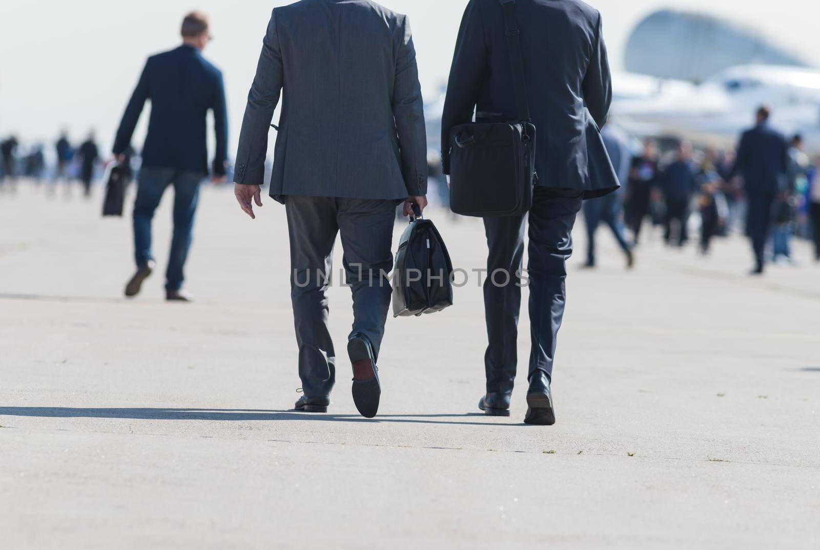 Business people walking down the street talking. Back view
