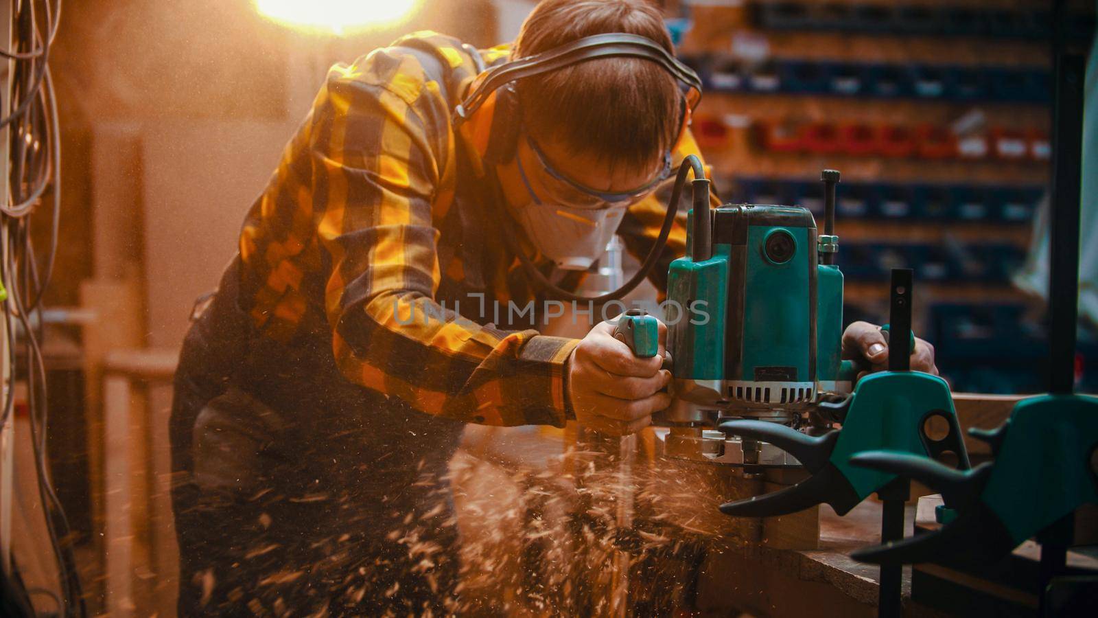 Carpentry indoors - a man woodworker polishes the top of the plank. Mid shot