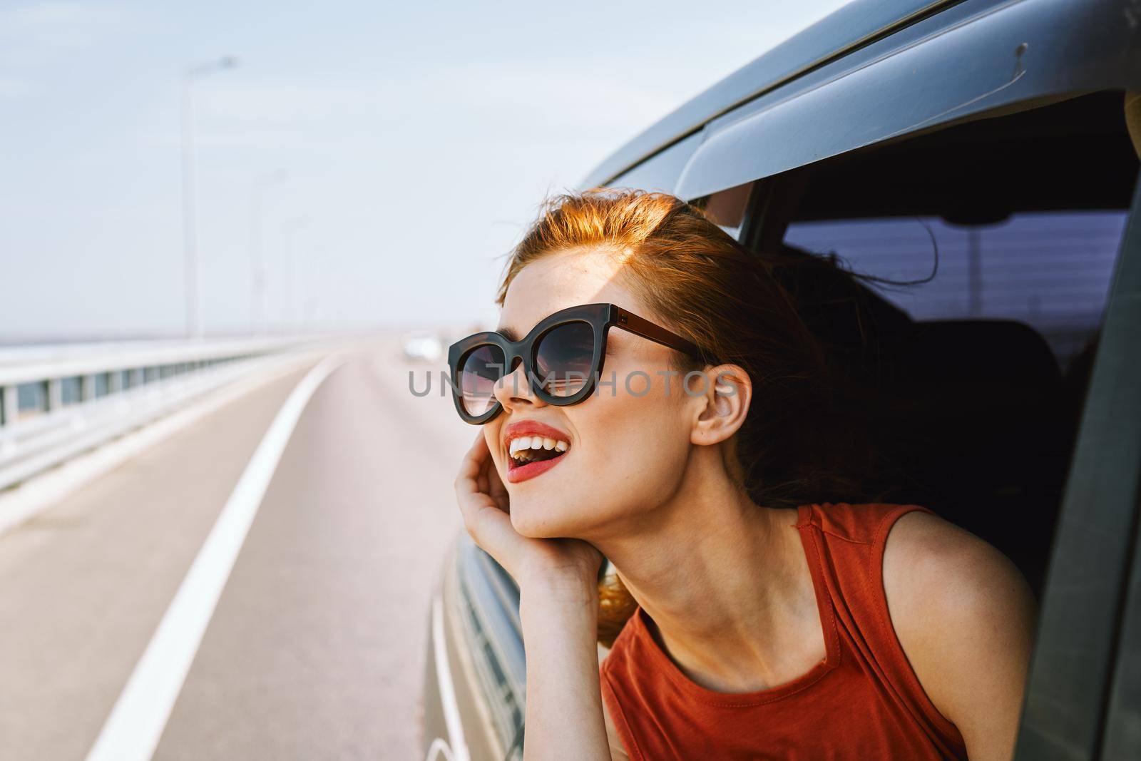 pretty woman in sunglasses rides in a travel car. High quality photo