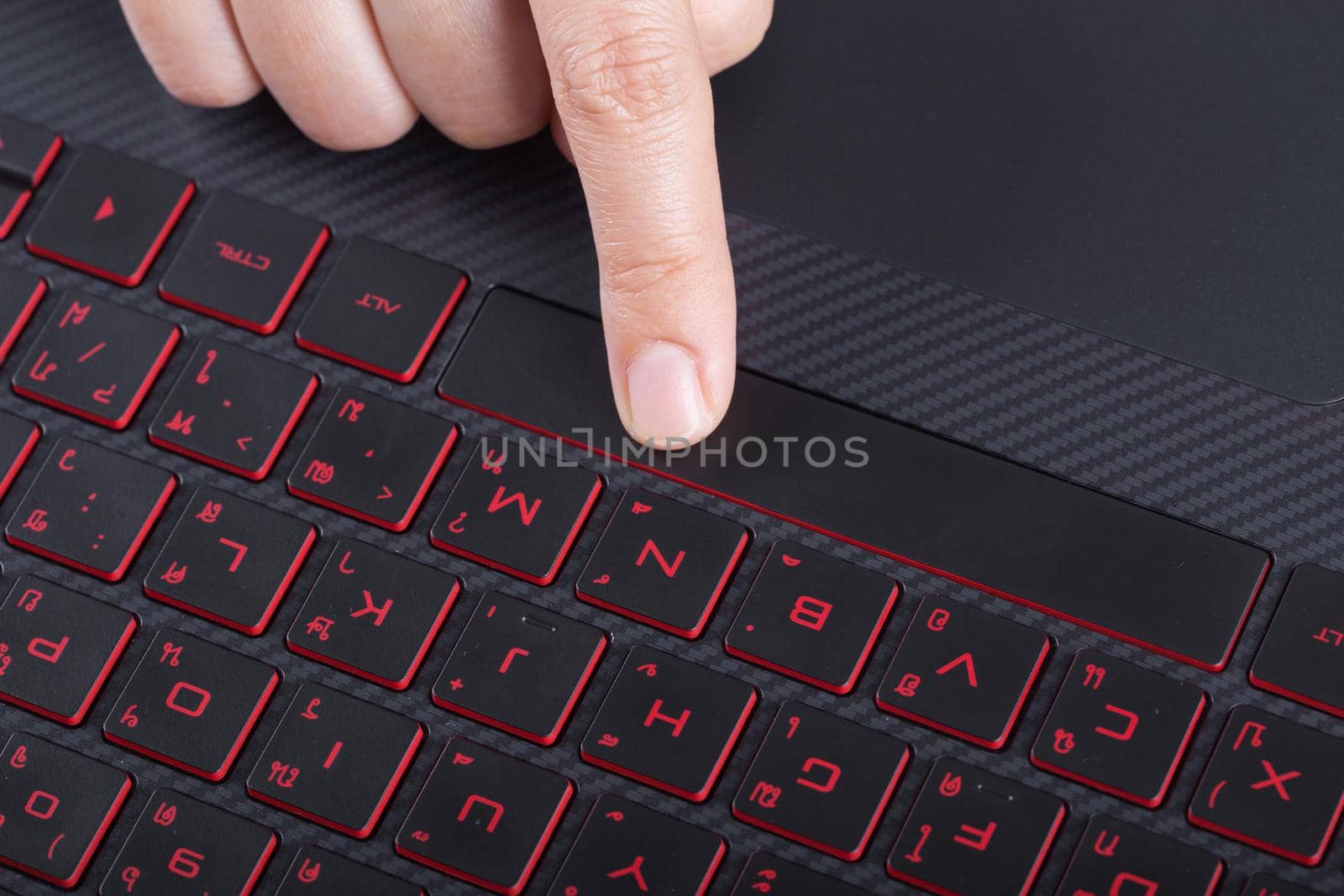 finger pushing space bar button on a laptop keyboard
