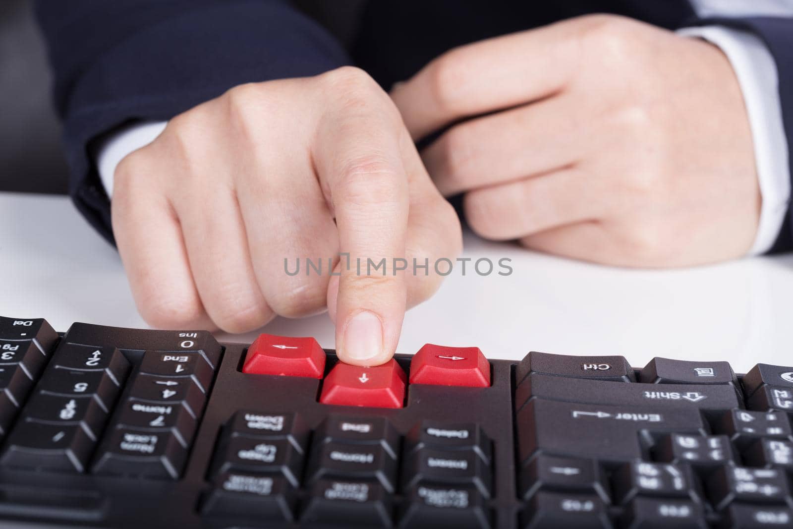 finger pushing arrow button on a keyboard computer