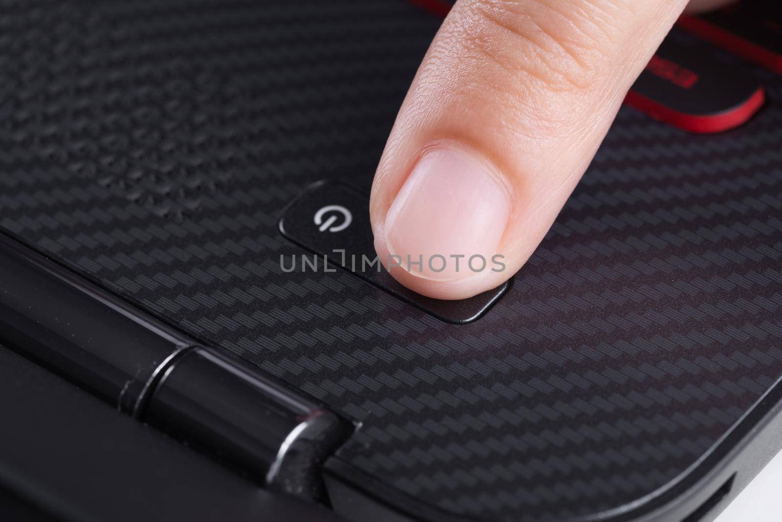 finger pushing power button on a laptop keyboard