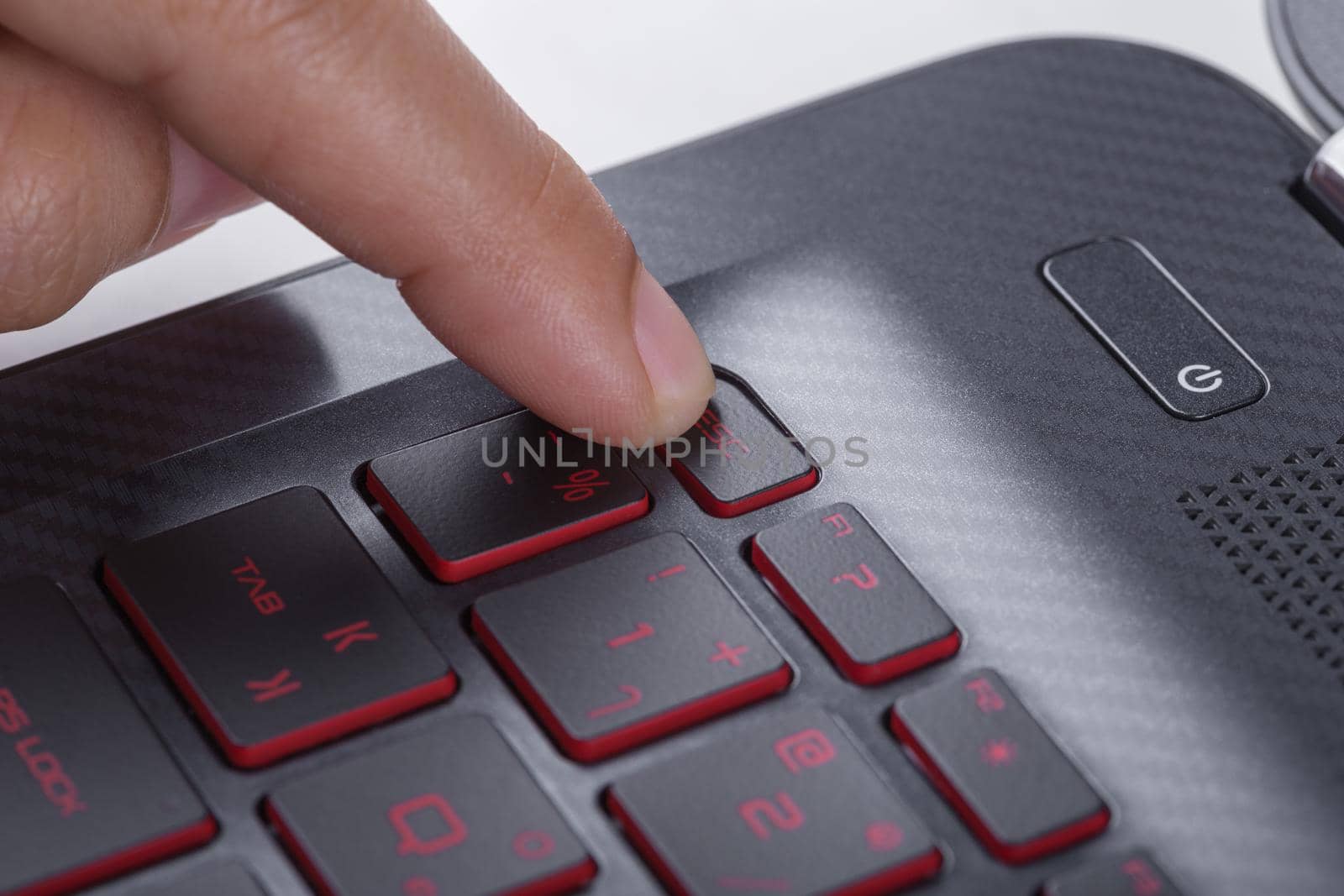 finger pushing esc button on a laptop keyboard