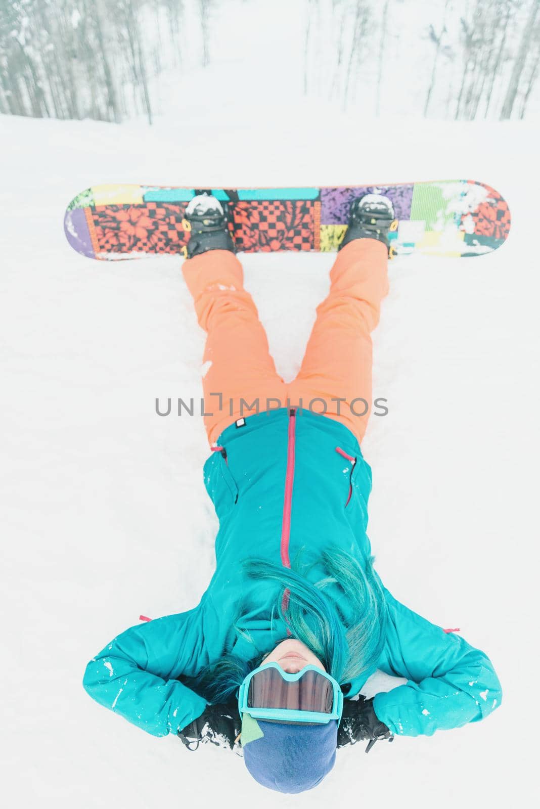Woman snowboarder lying on snow by alexAleksei