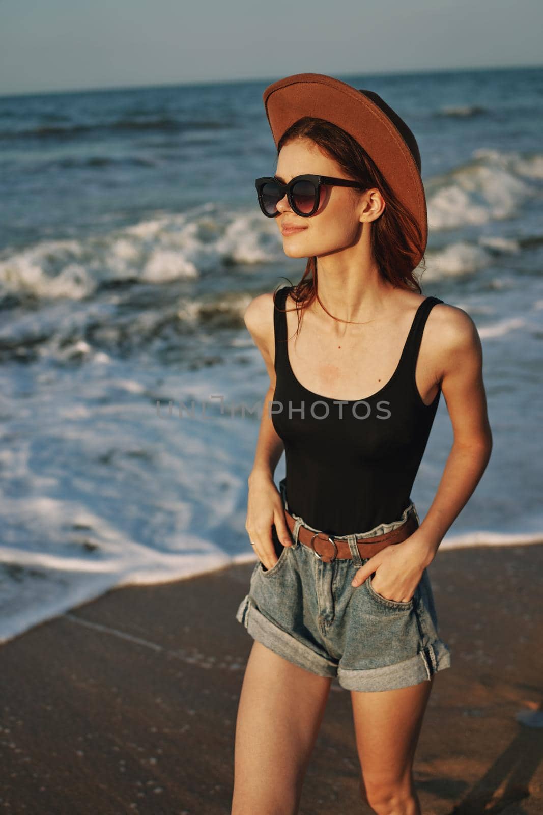 woman walking on the beach hat travel vacation sun. High quality photo