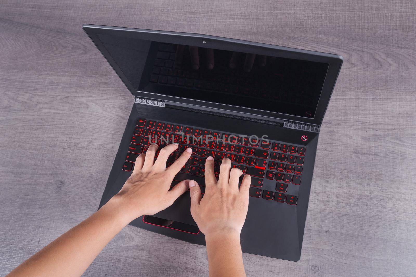 business hand typing keyboard of laptop on wood background