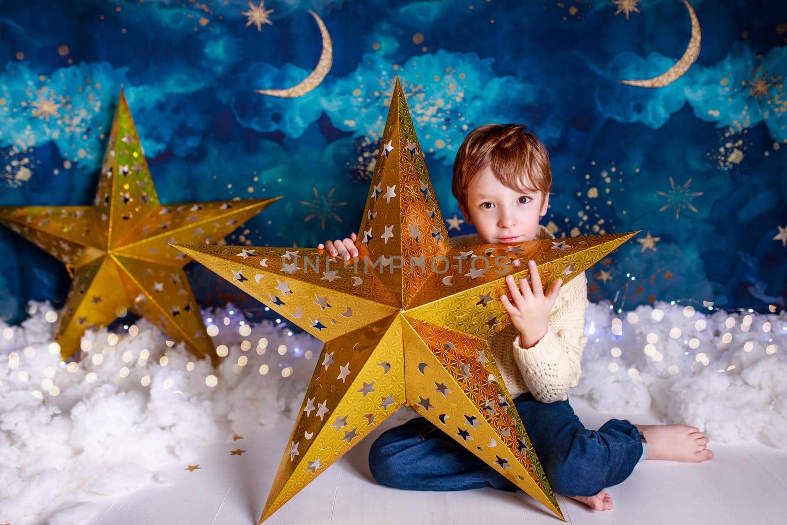 Handsome kid on christmas background holding a christmas star by lifesummerlin
