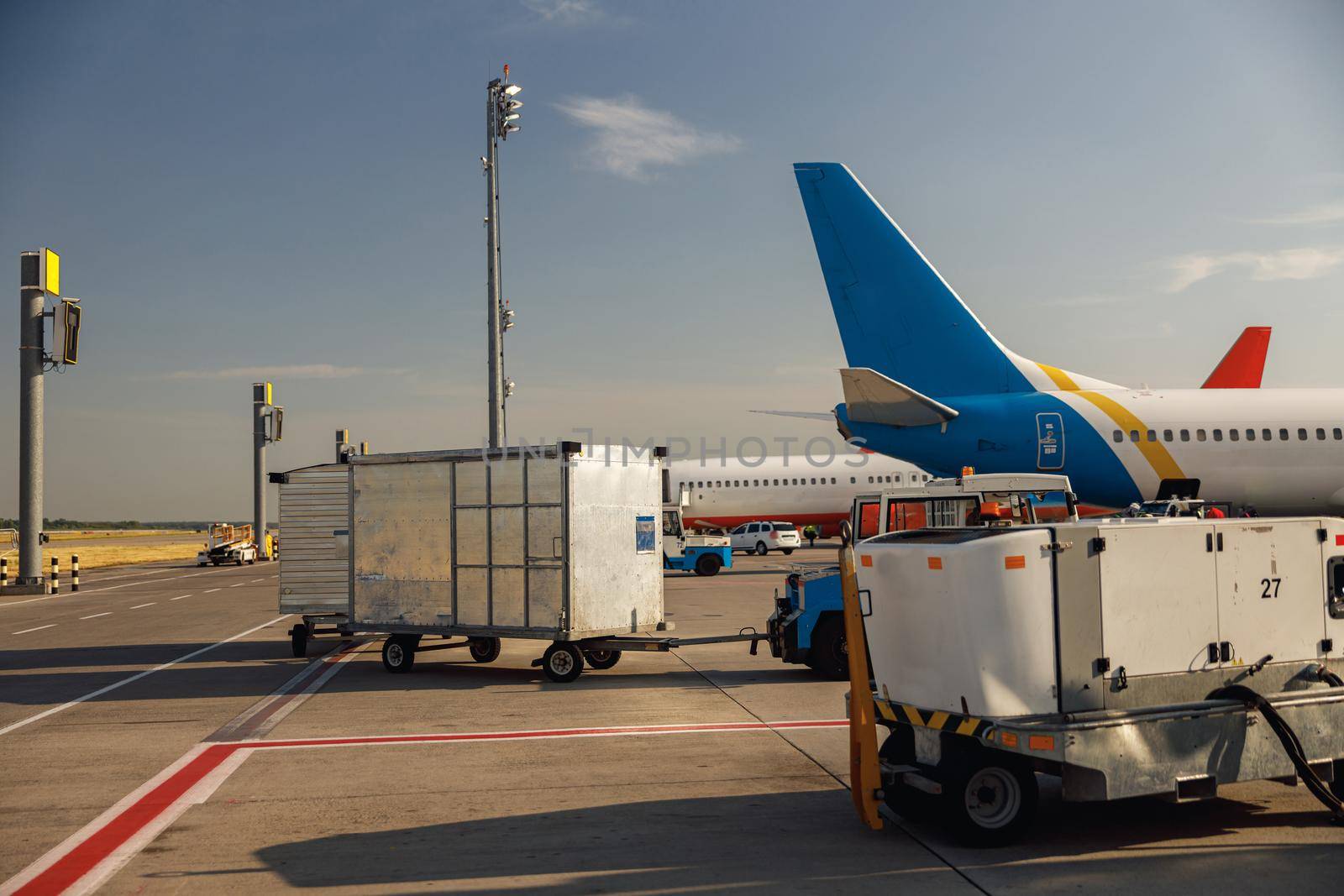 Airfield tractors near big modern airplane. Preparation of aircraft for boarding in airport hub on a daytime. Plane, shipping, transportation concept