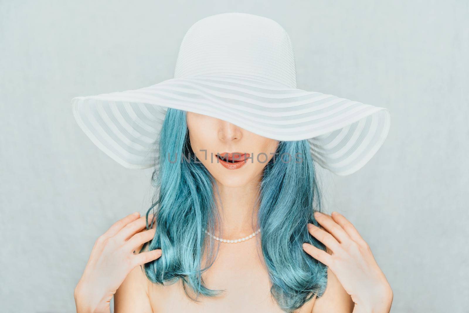 Pretty young woman with blue hair in a hat, fashion and beauty.