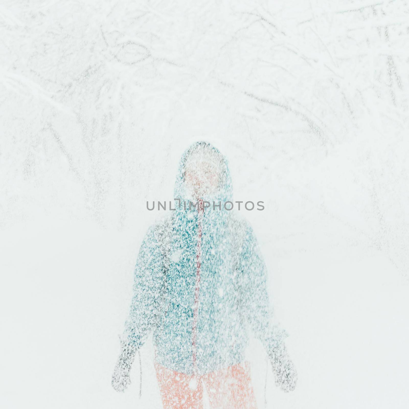 Young woman standing under falling snow in winter outdoor