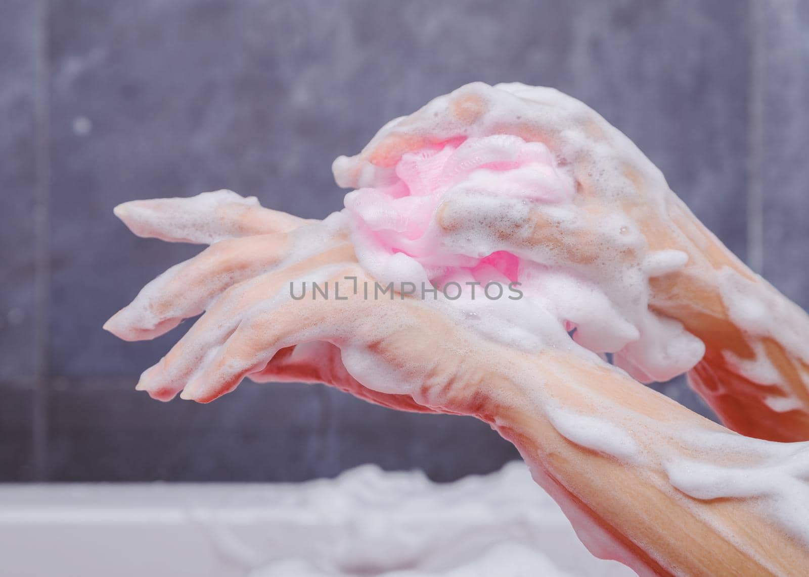 close up of woman washing hand with sponge in bathtub in the bathroom by geargodz