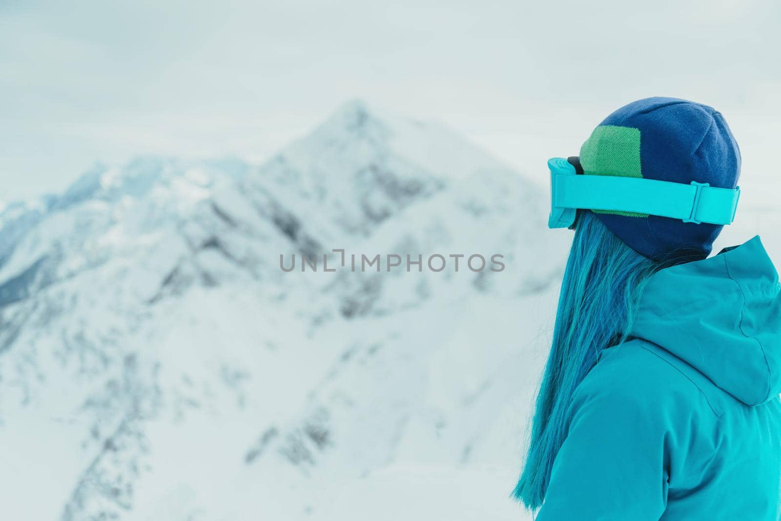 Woman looking at snowy mountains by alexAleksei