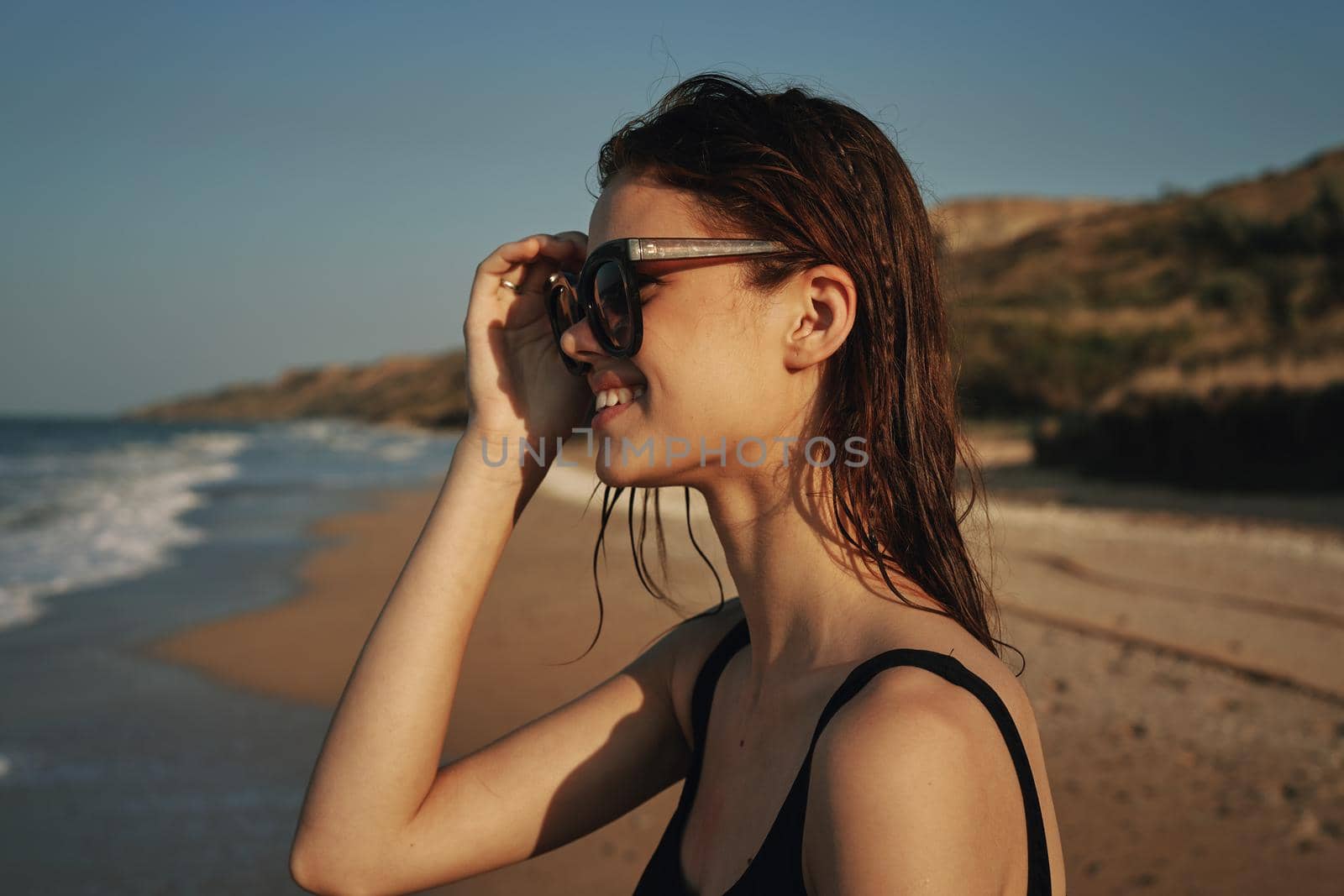 woman on the beach in sunglasses in a swimsuit sun. High quality photo