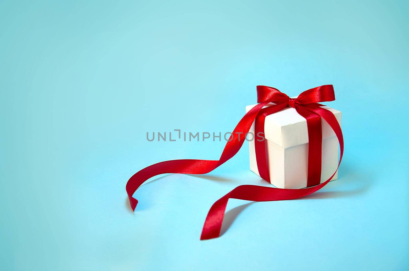 Christmas Gift's in White Box with Red Ribbon on Light Blue Background. New Year Holiday Composition Banner. Copy Space For Your Text
