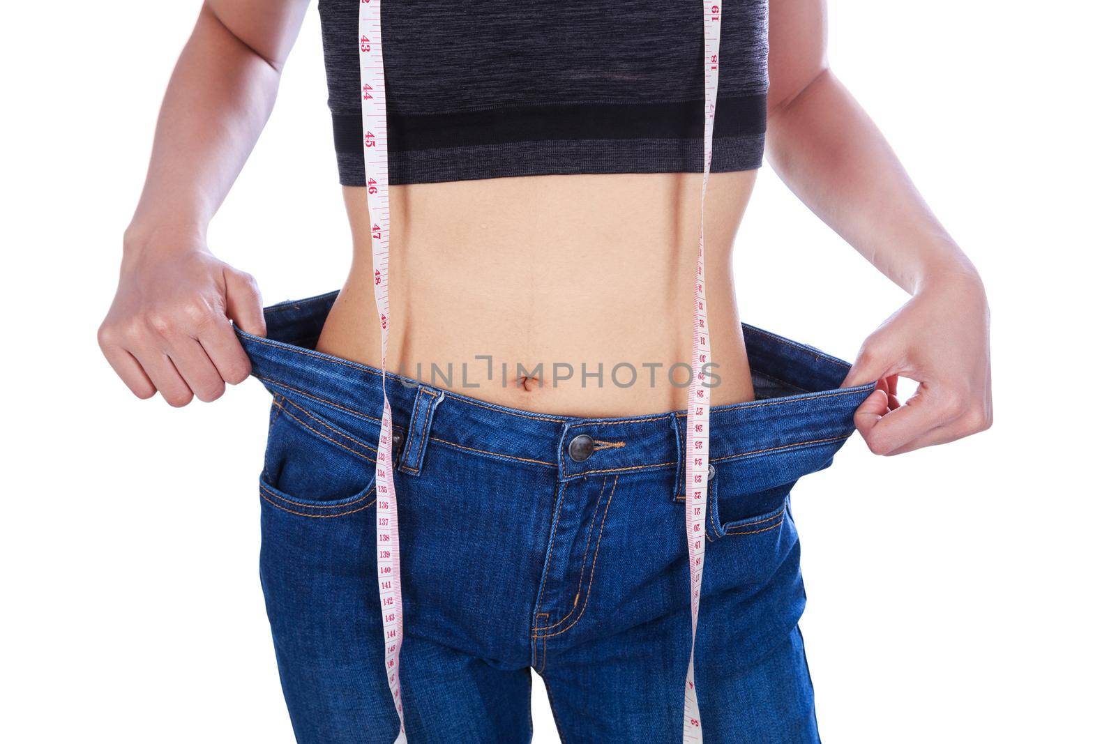 close up weight loss woman wearing her old jeans and measure tape isolated on a white background