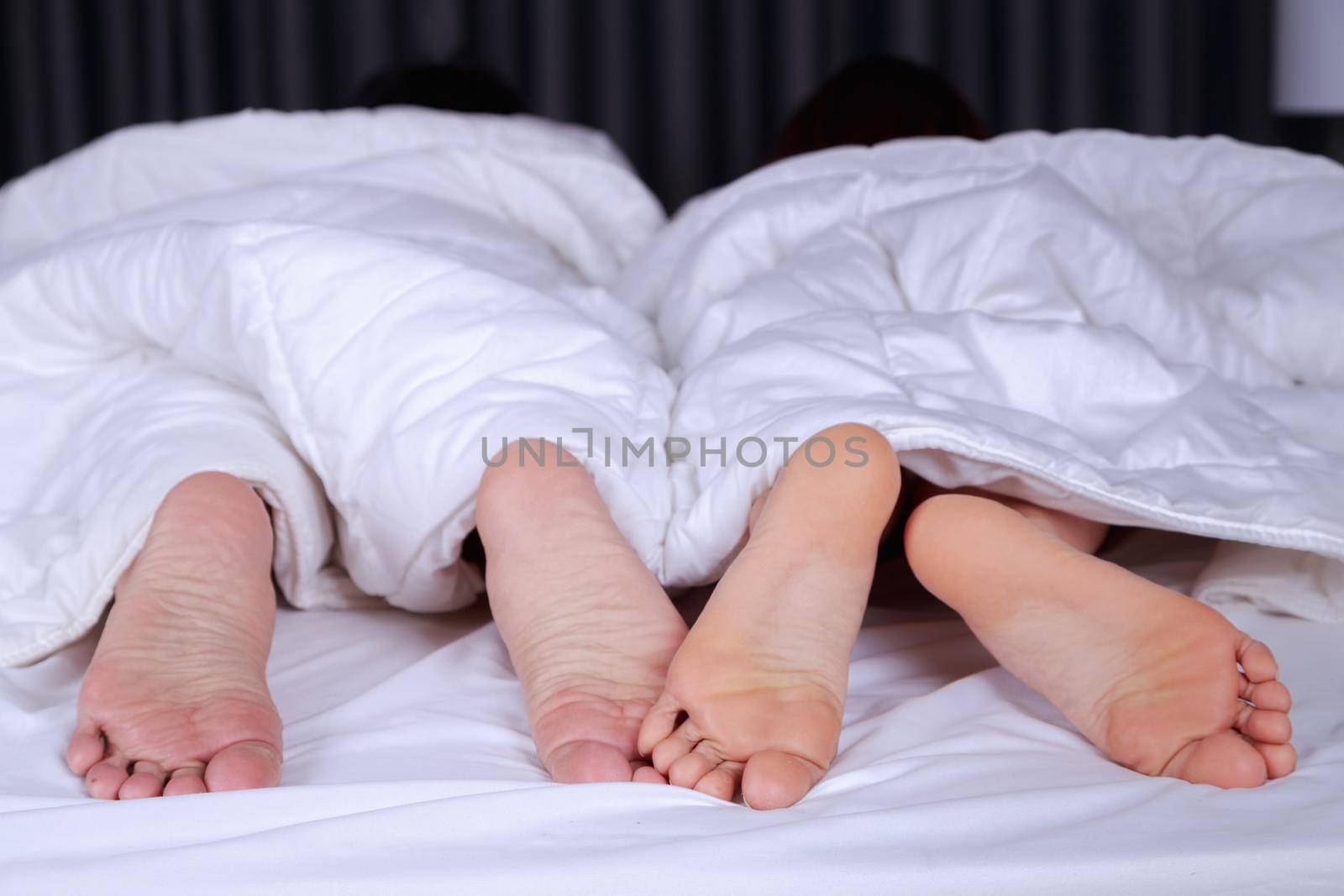 close up of four feet in a bed