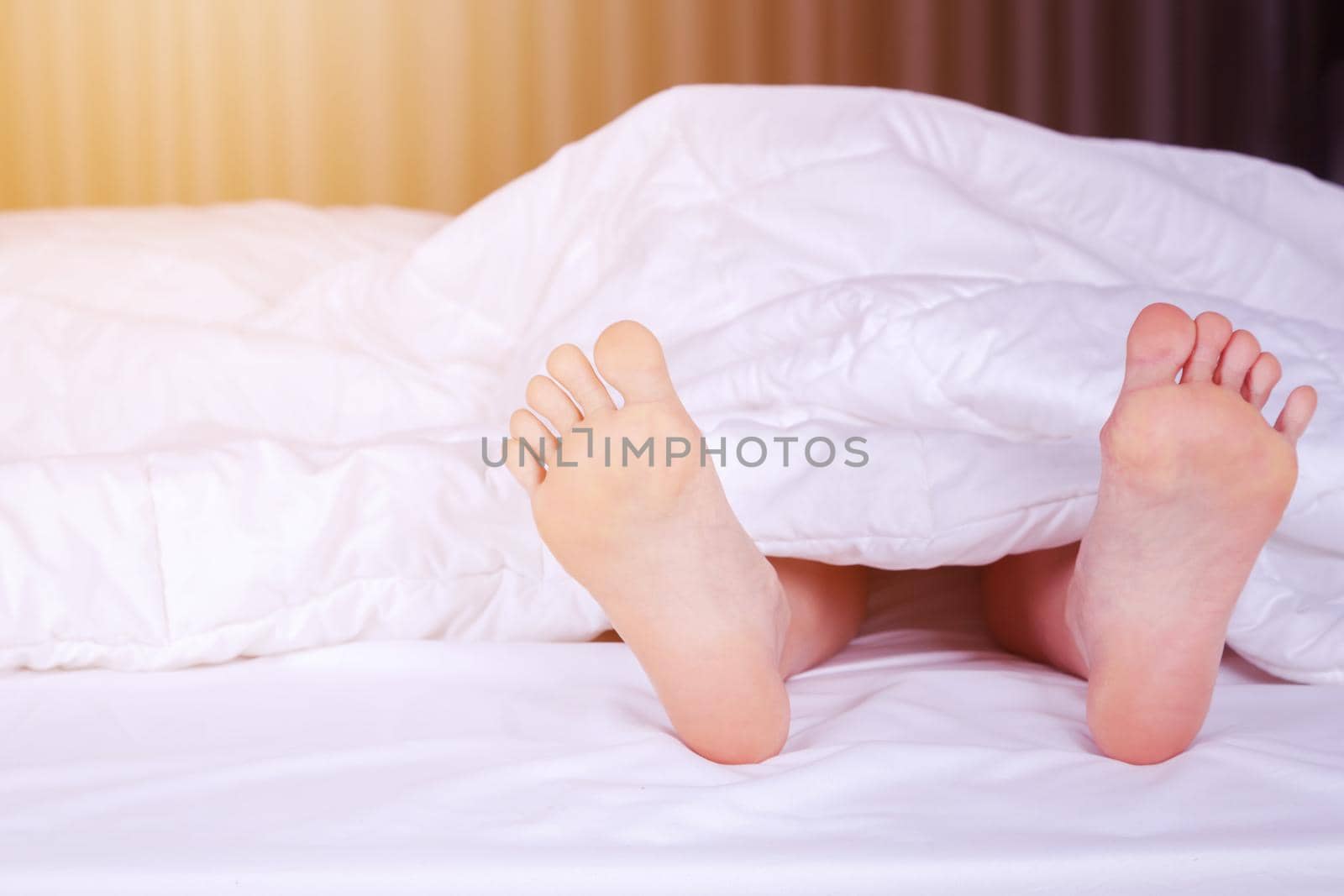 close up of two feet in a bed