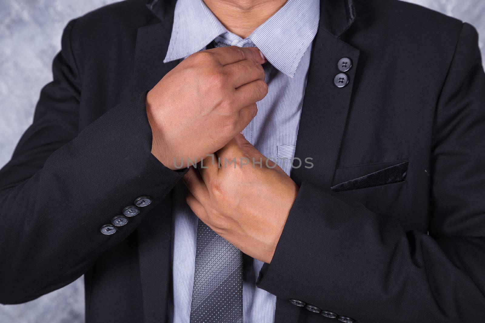 close up business man in a suit fixing his tie