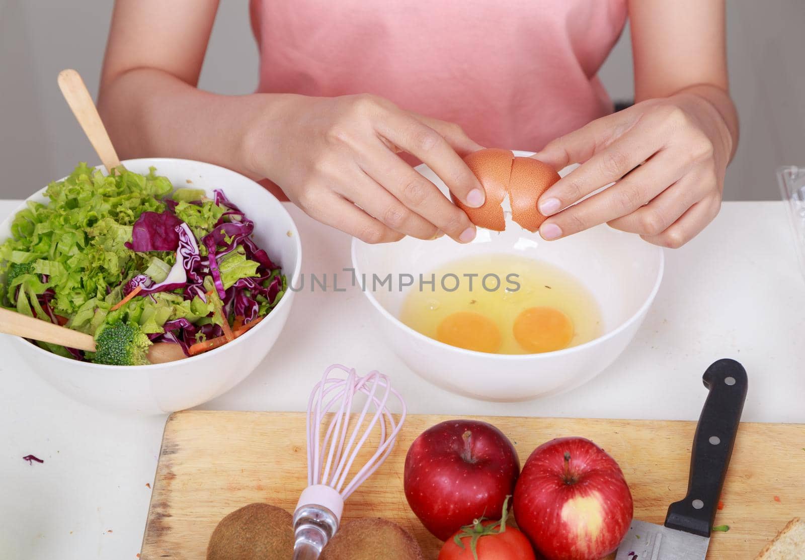 close up hand of woman smashing eggs in bowl at kitchen  by geargodz