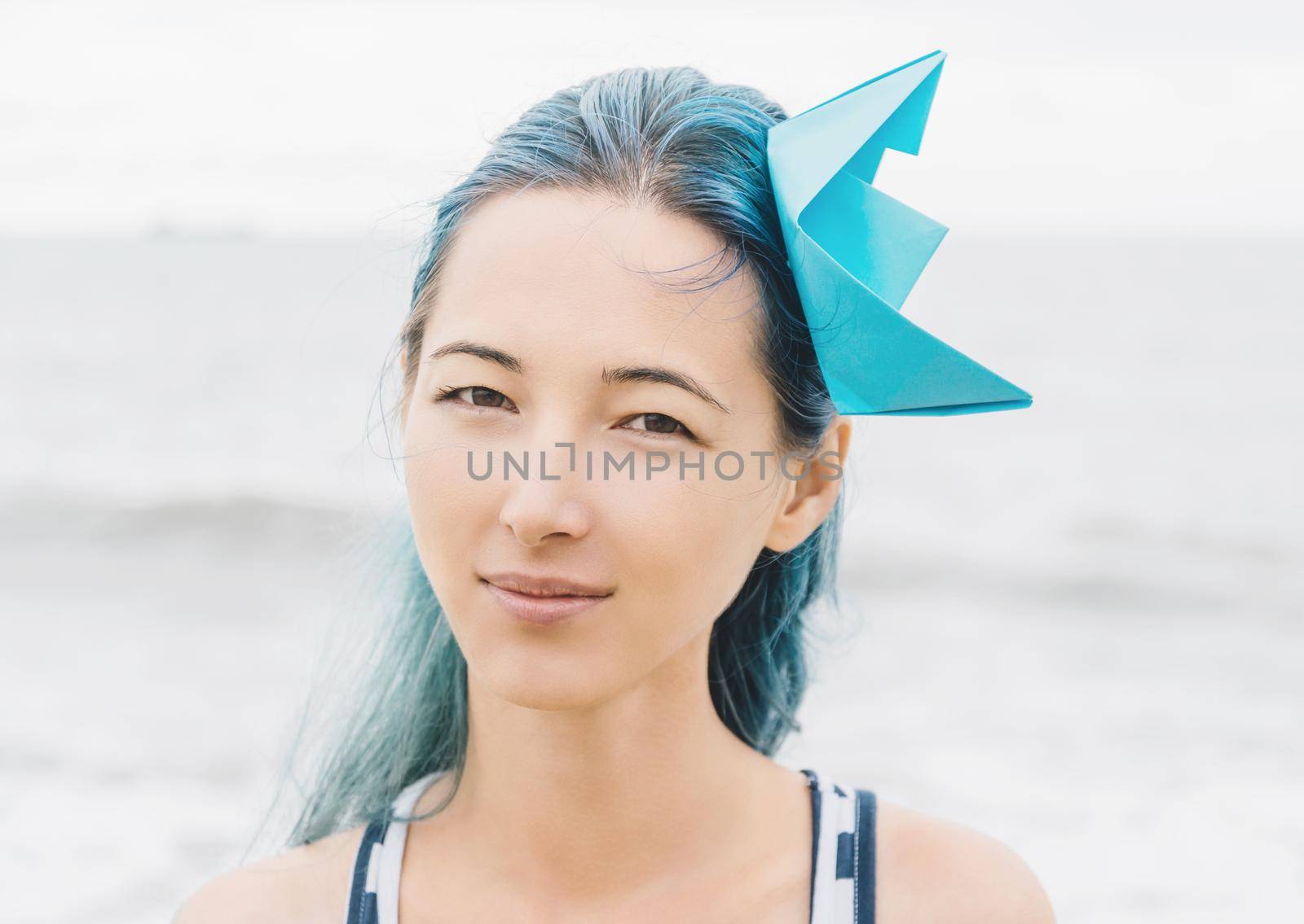Portrait of beautiful sailor style young woman on background of sea.