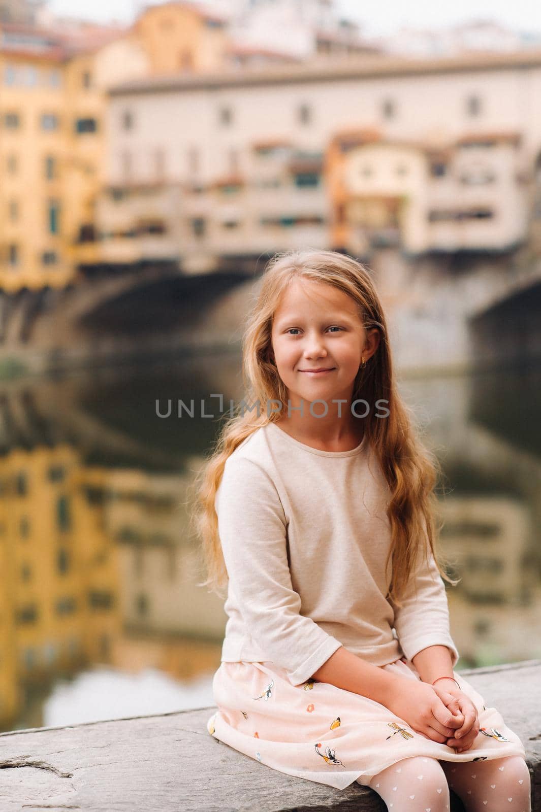 a little girl on the background of the Ponte Vecchio bridge in Florence.Family walk of the family in Italy.Tuscany.