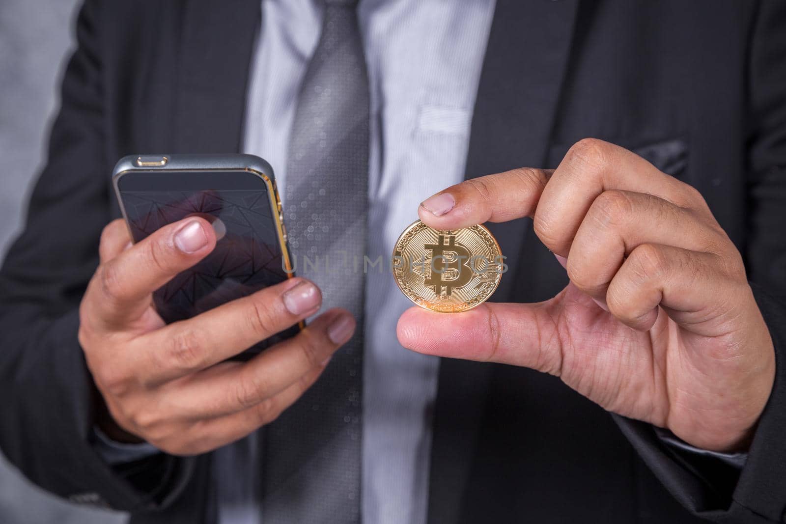 close up business man with bitcoin and using a mobile phone