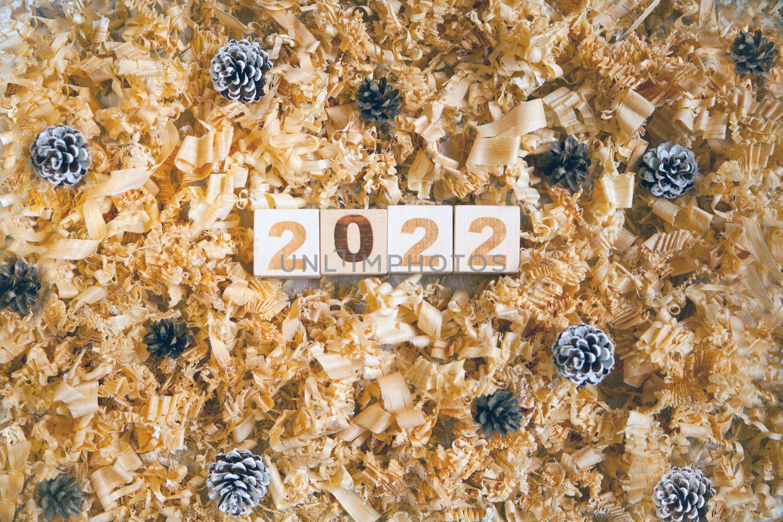 wooden numbers 2022 cubes symbolizng new year or Christmas celebration. pine cones and shavings. brown colors