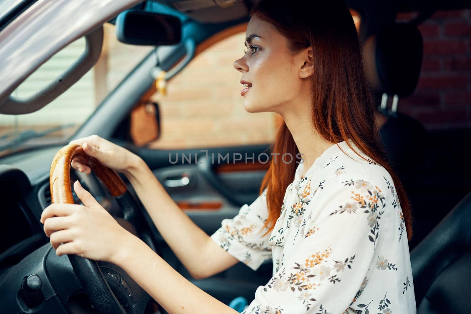 cheerful woman driving a car looks out of the window. High quality photo