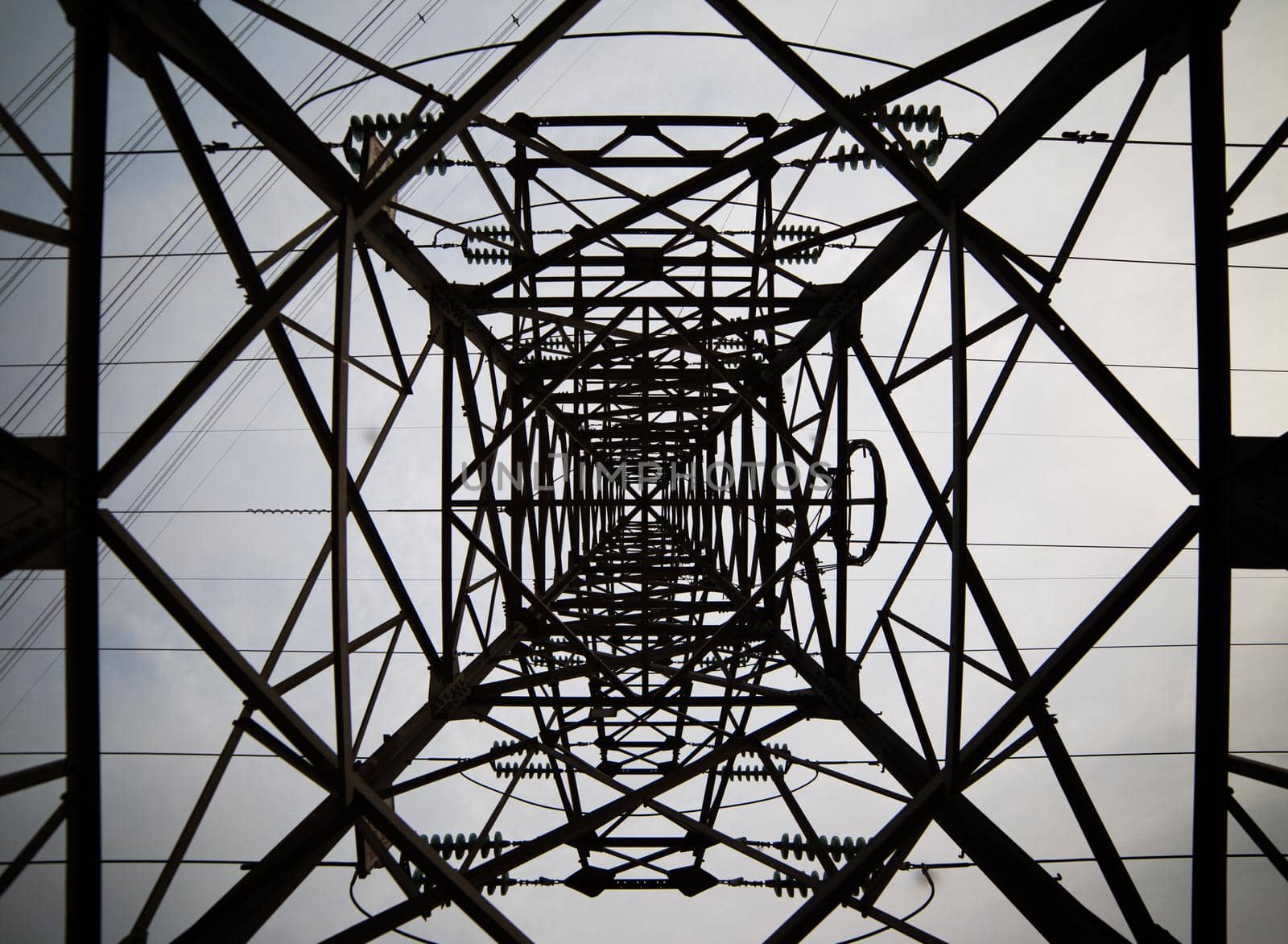Abstract pattern from bottom view of high voltage pole power transmission tower with clear sky sunny day background in monochrome tone. Green energy, environmental conservation concept. by whatwolf