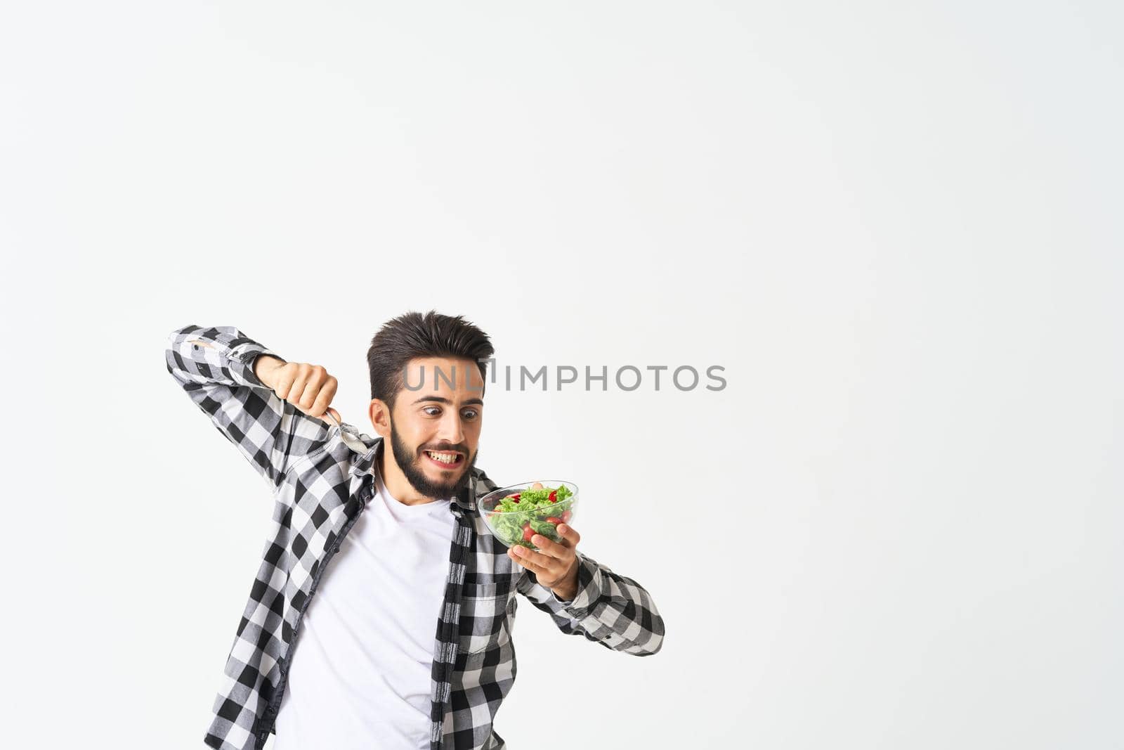 man in plaid shirt eating salad healthy food. High quality photo